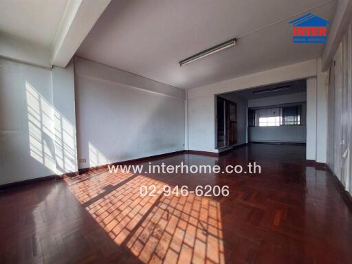 Spacious living room with natural lighting and hardwood floors