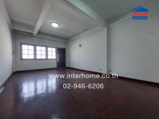 Spacious empty living room with hardwood floors and large windows