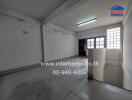 Spacious unfurnished room with large windows and visible wear