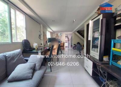 Spacious and well-lit living room with comfortable seating and modern amenities