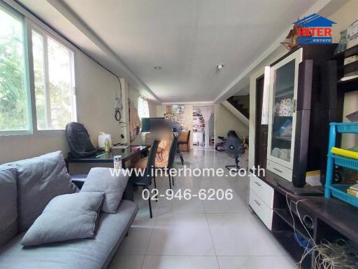 Spacious and well-lit living room with comfortable seating and modern amenities