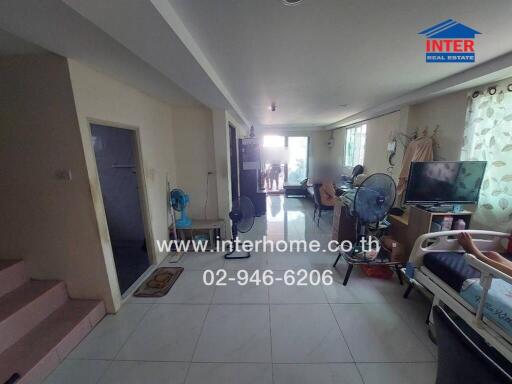 Spacious living room with natural light and multiple seating areas