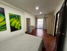 Spacious bedroom with wooden flooring and modern decor