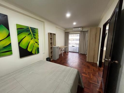 Spacious bedroom with wooden flooring and modern decor