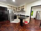 Spacious modern kitchen with stainless steel appliances and herringbone wood flooring