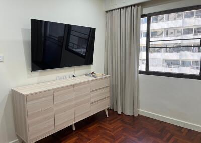 Modern living room with large TV and wooden flooring