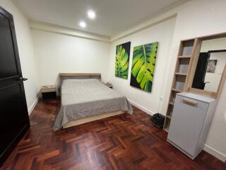 Spacious bedroom with wooden flooring and modern decor