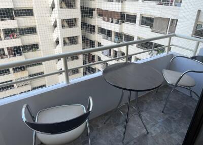 Modern balcony with a table and two chairs overlooking city buildings