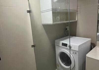 Modern laundry room with washing machine and glass enclosure
