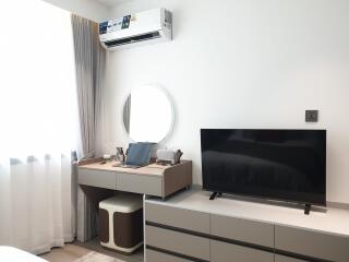 Modern bedroom with air conditioning, TV, and dressing table