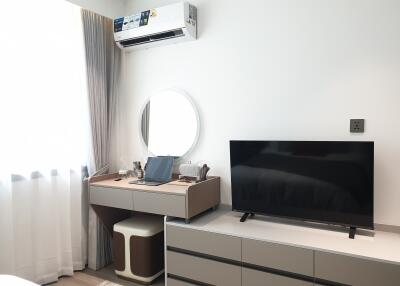 Modern bedroom with air conditioning, TV, and dressing table