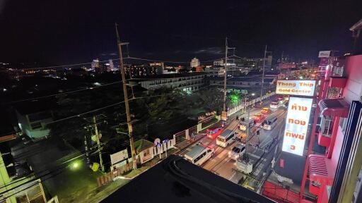 Nighttime view from balcony showing busy street and illuminated buildings