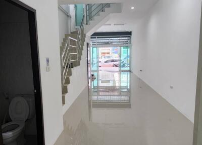 Bright and expansive hallway with staircase and bathroom access