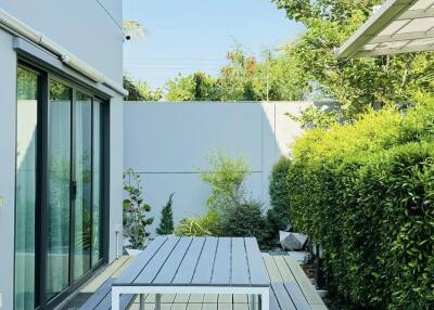 Modern outdoor patio with wooden decking and garden view