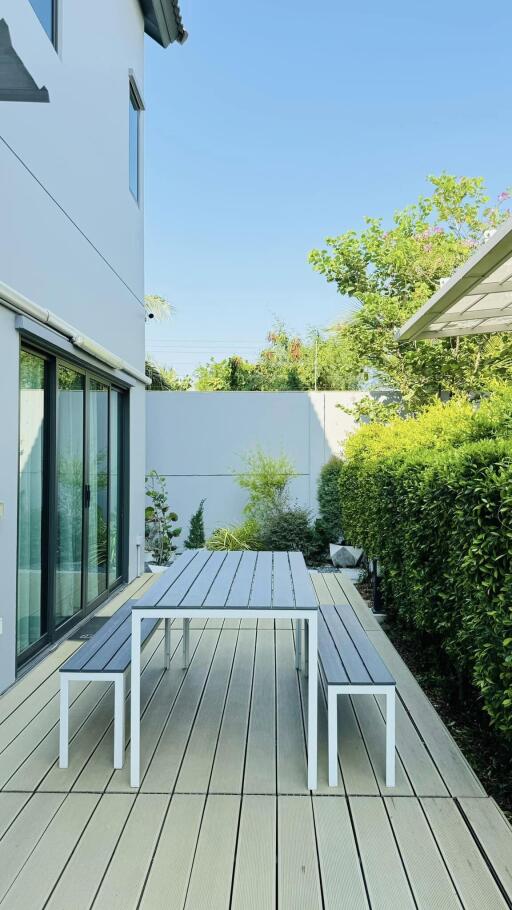 Modern outdoor patio with wooden decking and garden view