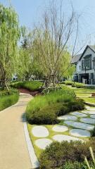 Lush green garden pathway leading to a modern house