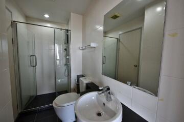 Modern bathroom with glass shower enclosure and white ceramic fixtures