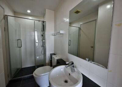 Modern bathroom with glass shower enclosure and white ceramic fixtures