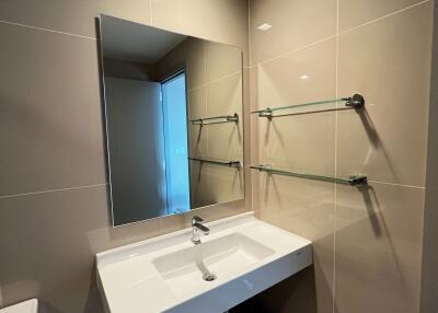 Modern bathroom interior with wall-mounted sink, mirror, and glass shower