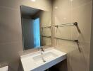 Modern bathroom interior with wall-mounted sink, mirror, and glass shower