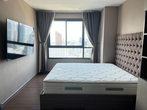 Contemporary bedroom with large window city view and modern furnishings