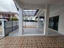 Spacious covered porch with decorative tiled flooring and multiple access points