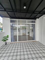 Spacious covered patio with patterned tile flooring and glass doors