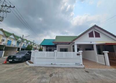 Suburban single-family home with white gate and tiled roofs