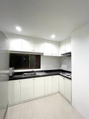 Modern kitchen with white cabinetry and stainless steel appliances