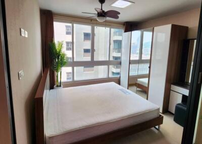 Modern bedroom with large windows and a view of the city