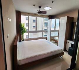 Modern bedroom with large windows and a view of the city