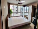 Modern bedroom with large windows and a view of the city