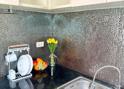 Modern kitchen with stainless steel sink and mosaic tile backsplash