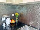 Modern kitchen with stainless steel sink and mosaic tile backsplash