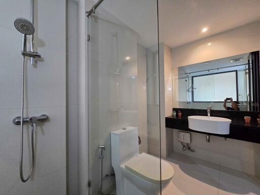 Modern bathroom with glass shower and well-lit vanity area