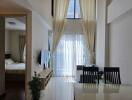 Bright living room with dining area and view into the bedroom