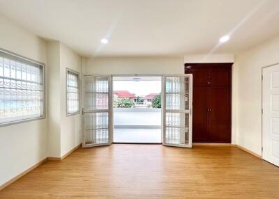 Spacious and brightly lit living room with wooden flooring and large windows