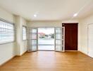 Spacious and brightly lit living room with wooden flooring and large windows