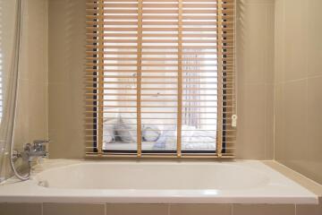 Modern bathroom with large window and wooden blinds