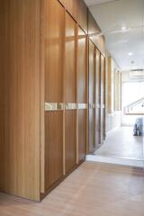 Modern residential hallway featuring sleek wooden cabinets