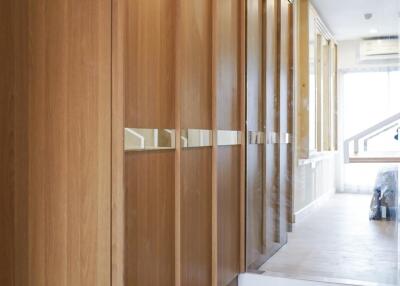 Modern residential hallway featuring sleek wooden cabinets