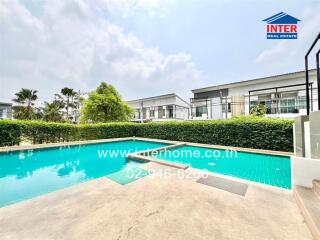 Inviting residential pool area with surrounding greenery and modern homes in the background