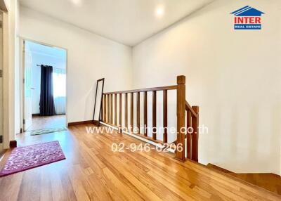 Spacious hallway with wooden flooring and natural lighting