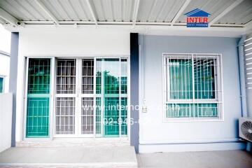 Modern building facade with green accented windows under a protective awning