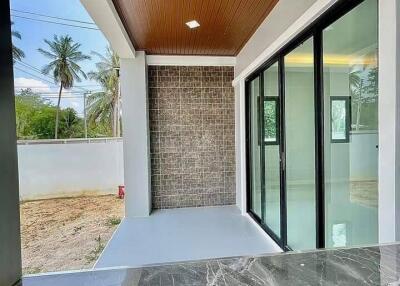 Stylish covered patio with modern finishes featuring marble flooring and a brick accent wall