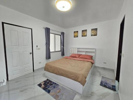 Modern bedroom with white walls and a large window