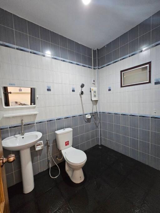 Modern bathroom with blue and white tiles, shower, toilet and sink