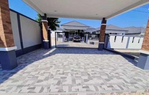 Spacious paved driveway with covered entrance and secure gate