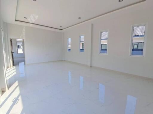 Spacious and well-lit empty living room with white walls and glossy floor