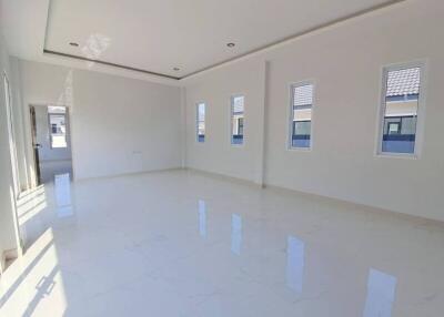 Spacious and well-lit empty living room with white walls and glossy floor